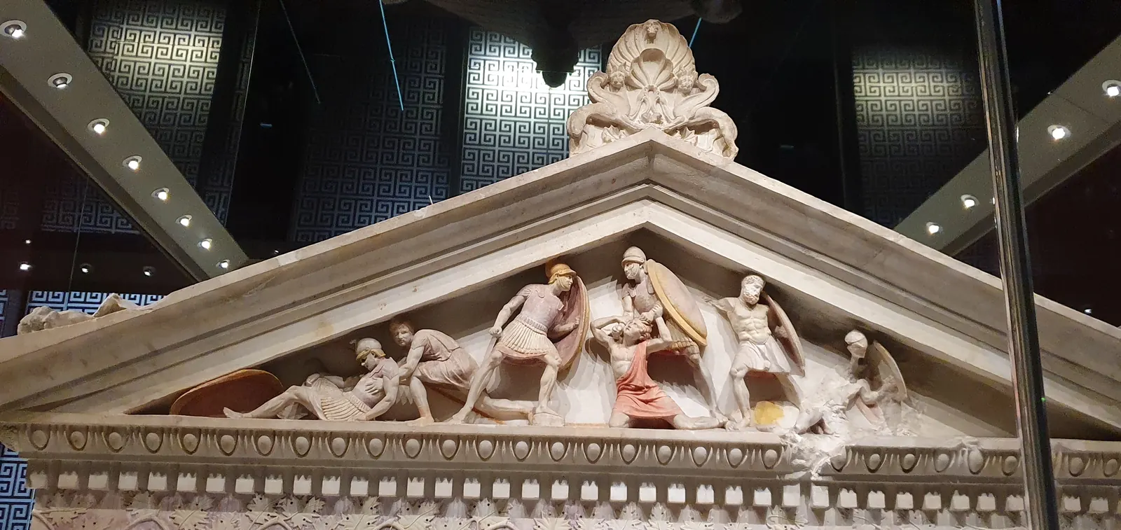 A carved marble pediment from the Alexander Sarcophagus, showing soldiers in combat, with traces of the original paint