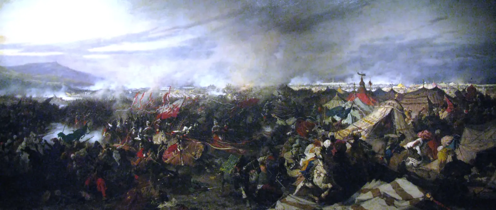 A panoramic oil painting depicting the 1683 cavalry charge at the Battle of Vienna, with Polish hussars and allied cavalry crashing into the Ottoman camp