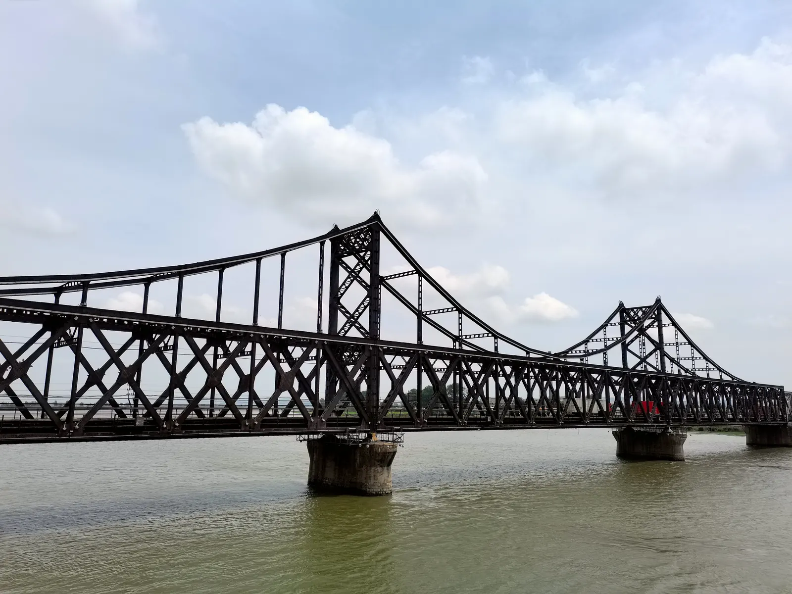 The Sino-Korean Friendship Bridge crossing the Yalu River between Dandong, China, and Sinuiju, North Korea, with the city skyline of Dandong in the background