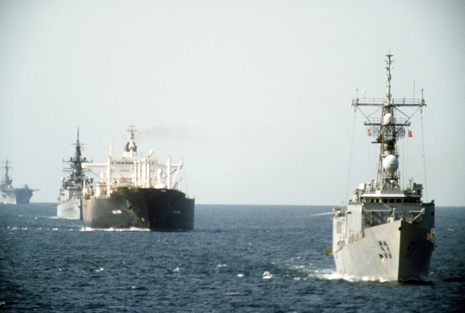 A US Navy frigate leads a reflagged tanker and other warships in convoy through the Persian Gulf in 1987