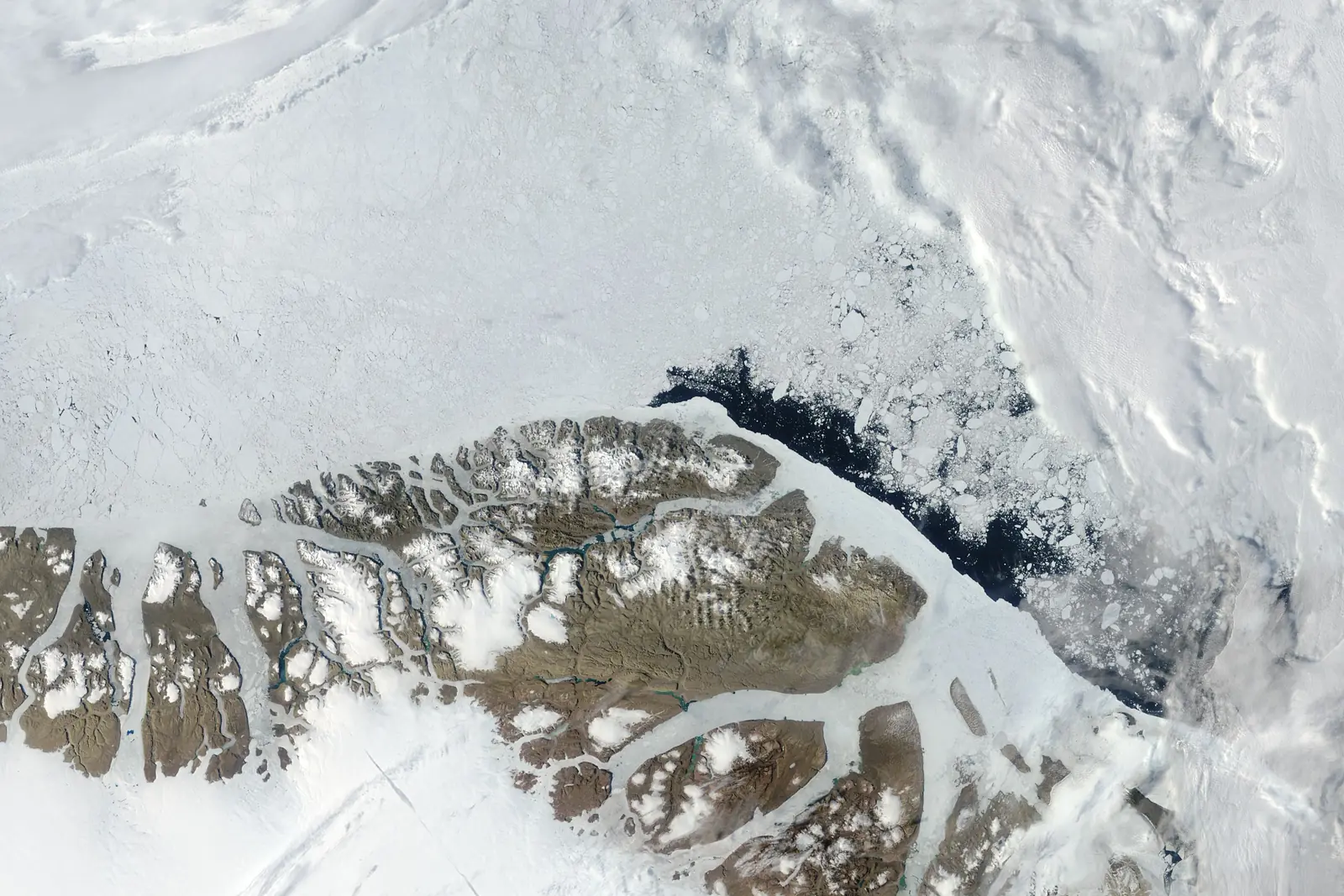 Greenland seen from space, its vast white ice sheet filling almost the entire island with only a thin rim of bare coast
