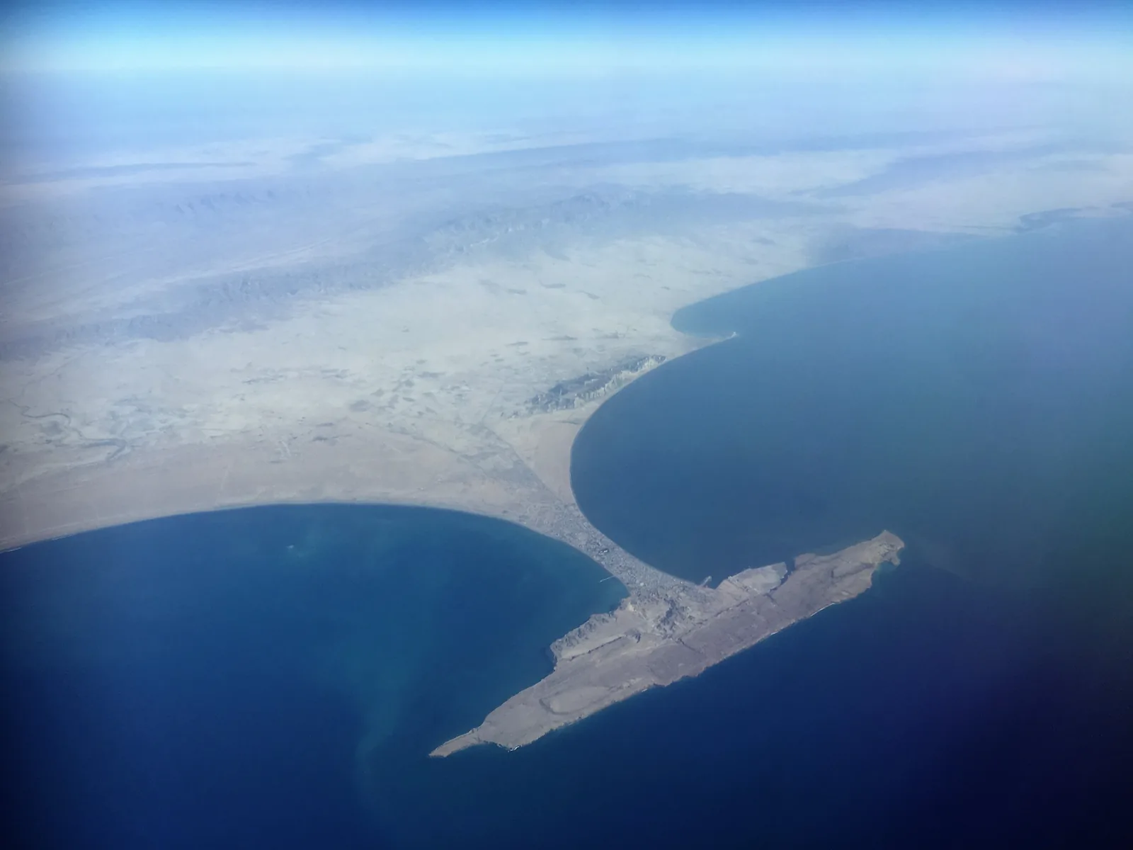 Aerial view of Gwadar, the Chinese-built deep-water port on Pakistan's Arabian Sea coast, its breakwaters reaching into the blue water beside a bare desert peninsula