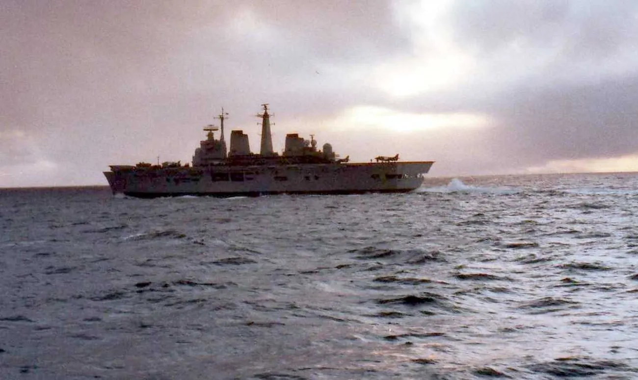 HMS Invincible, a British aircraft carrier, at sea under grey skies during the Falklands War