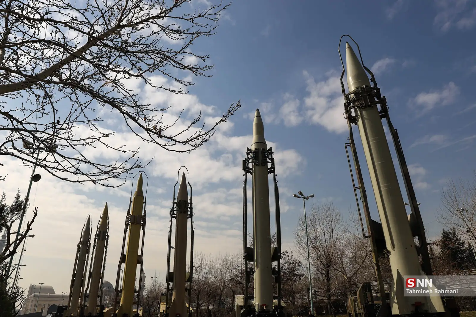 A row of Iranian ballistic missiles on display against a winter sky at a military exhibition in Tehran