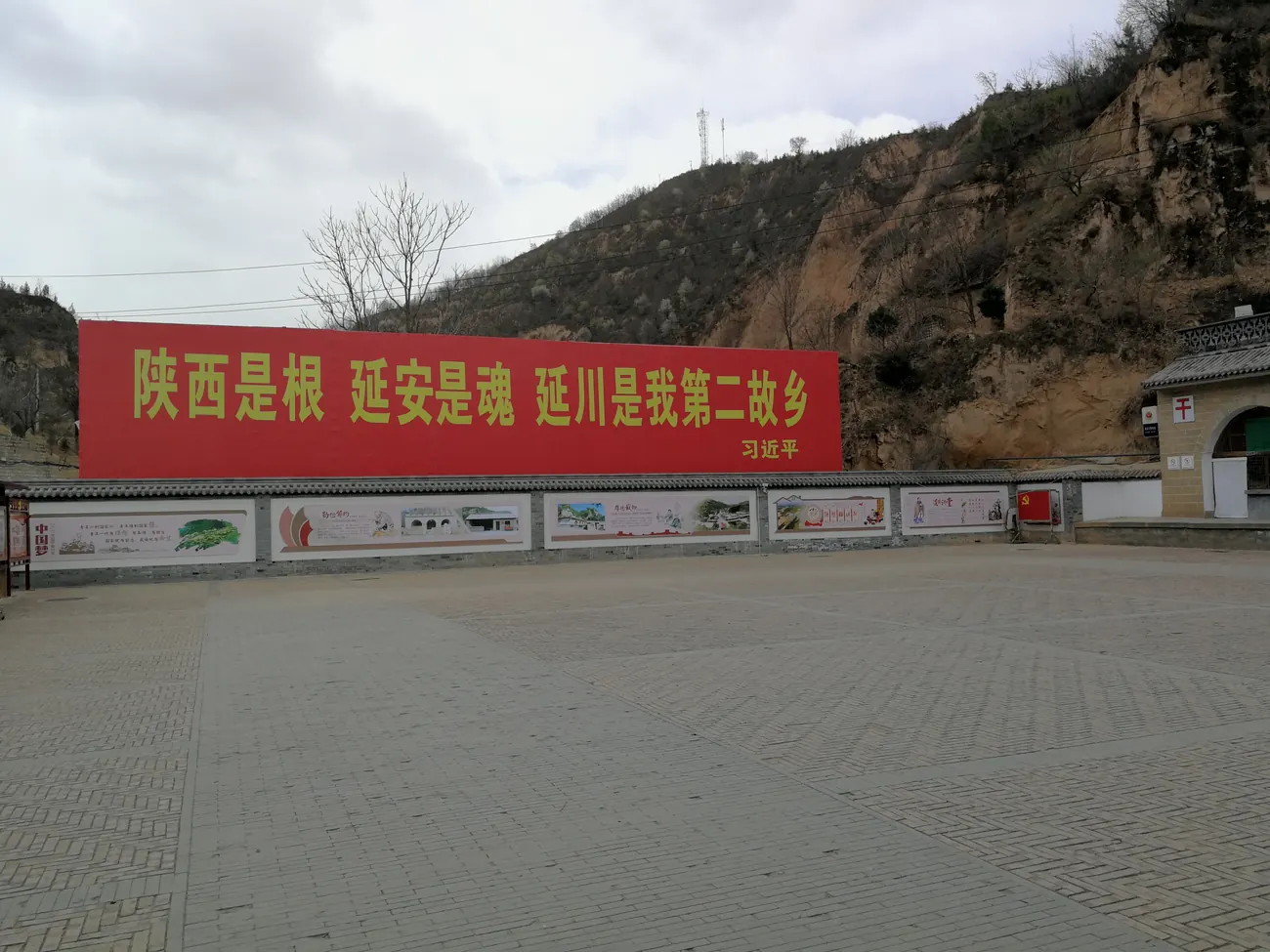 The village of Liangjiahe today, with newer buildings and a large red slogan on a hillside