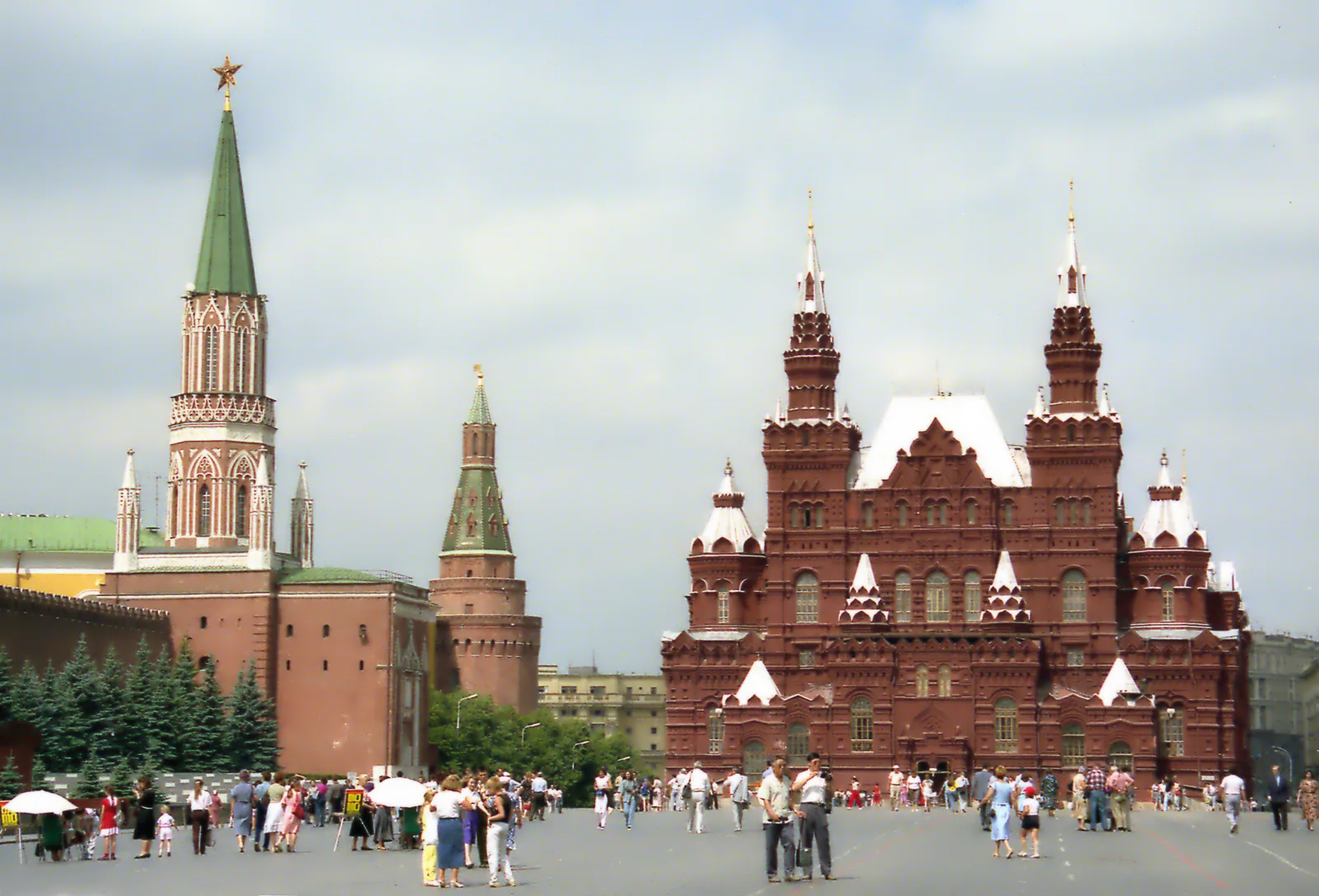 Red Square in Moscow with the Kremlin wall, Nikolskaya Tower, and the State Historical Museum, crowds of people in summer 1991