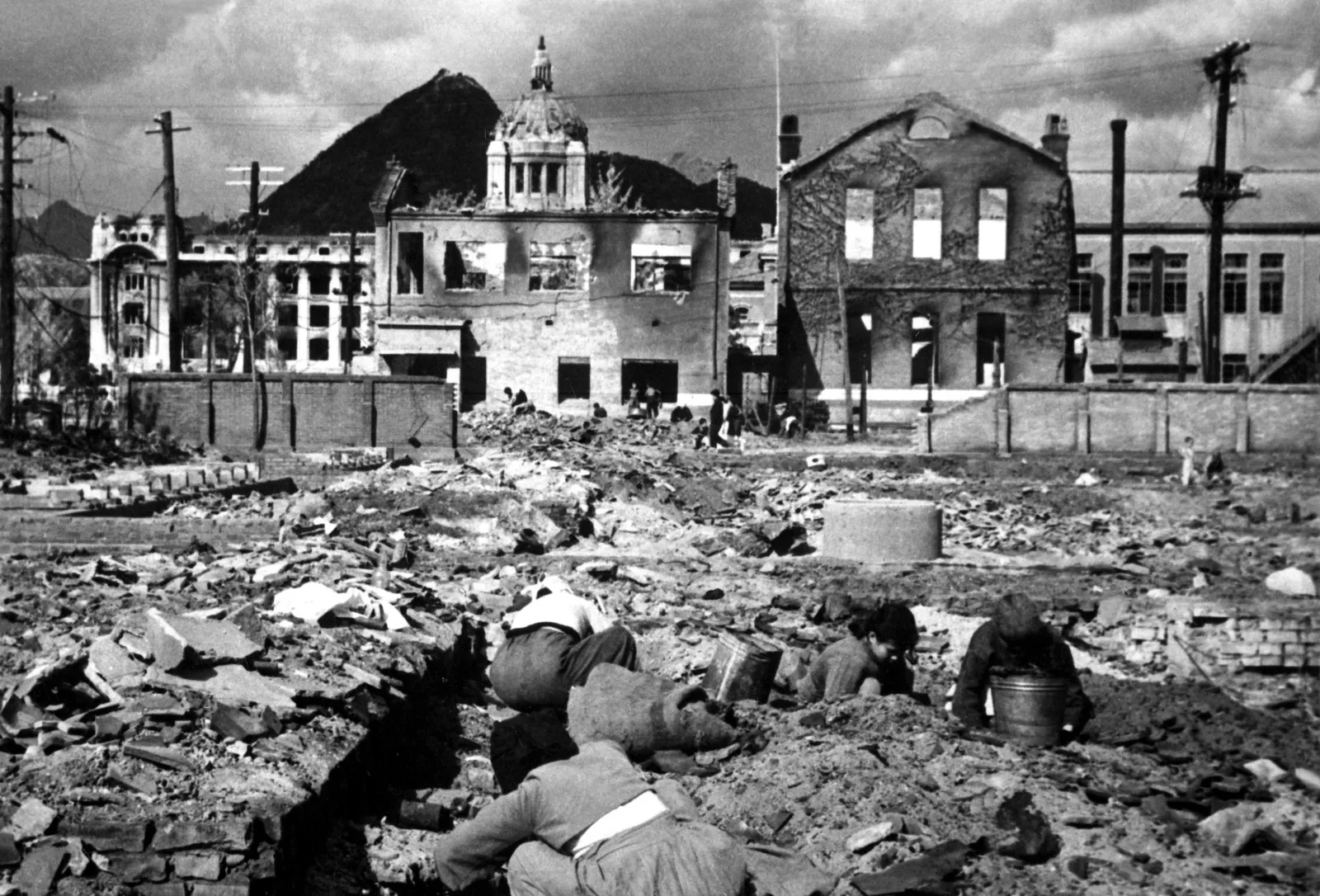 Korean women and children searching through the rubble of destroyed buildings in Seoul