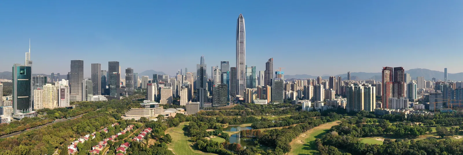 Panoramic view of the Shenzhen skyline with the Ping An Finance Centre towering over the Futian central business district, green parkland in the foreground