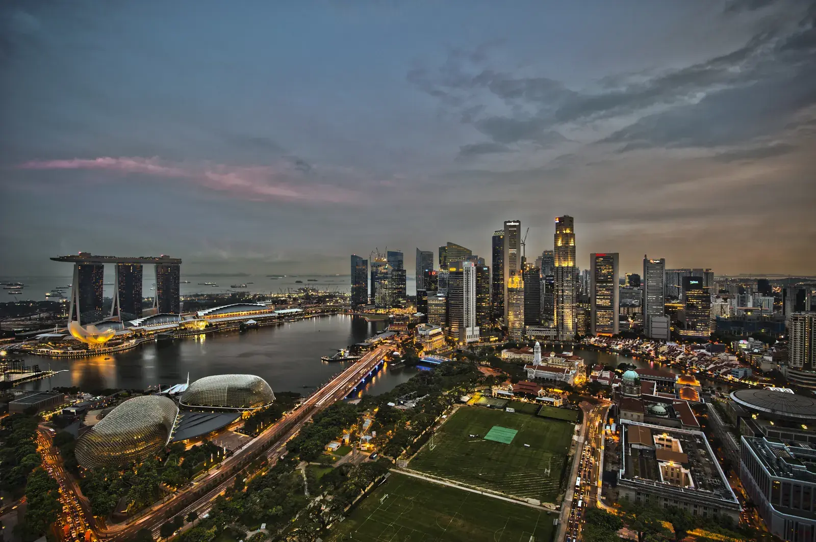 The Singapore skyline at dusk with Marina Bay Sands and the Central Business District lit up along the waterfront