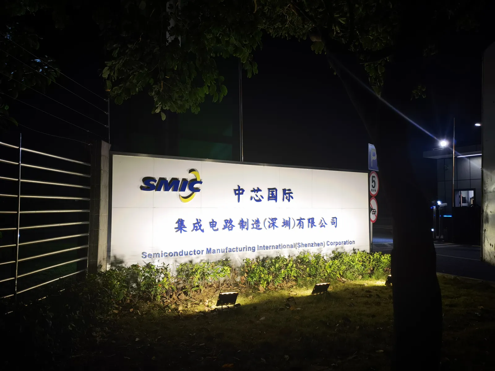The illuminated entrance sign of SMIC's semiconductor fabrication plant in Shenzhen at night
