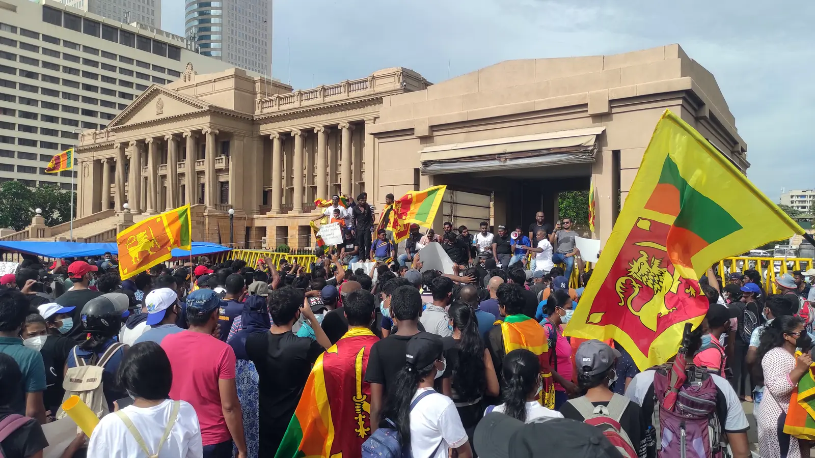 A large crowd of protesters waving Sri Lankan flags in front of the Presidential Secretariat in Colombo