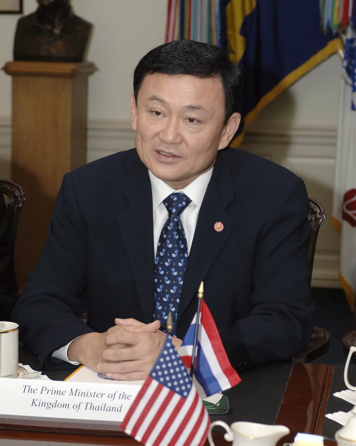 Thaksin Shinawatra in a dark suit at the Pentagon in 2005