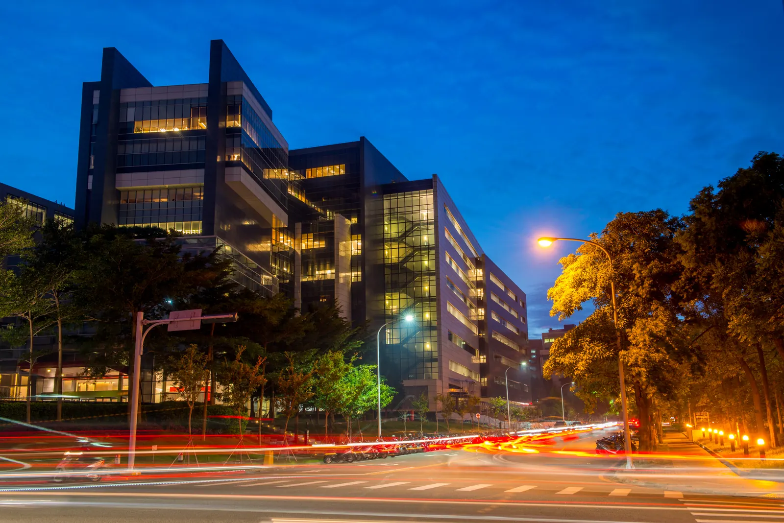 TSMC's Fab 12A headquarters building in Hsinchu at dusk, with light trails from passing traffic