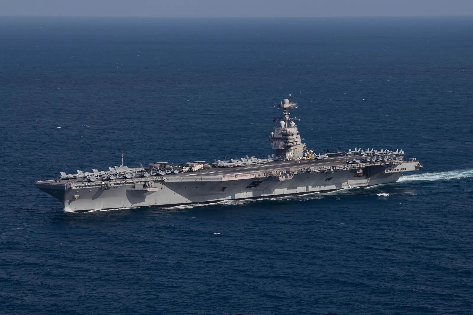 The aircraft carrier USS Gerald R. Ford underway in the Atlantic Ocean, seen from above with aircraft on its flight deck