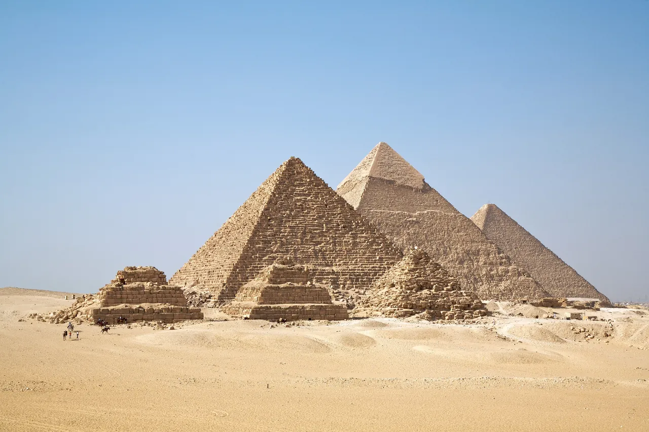 The three great pyramids of Giza and the smaller queens' pyramids in the desert under a clear sky