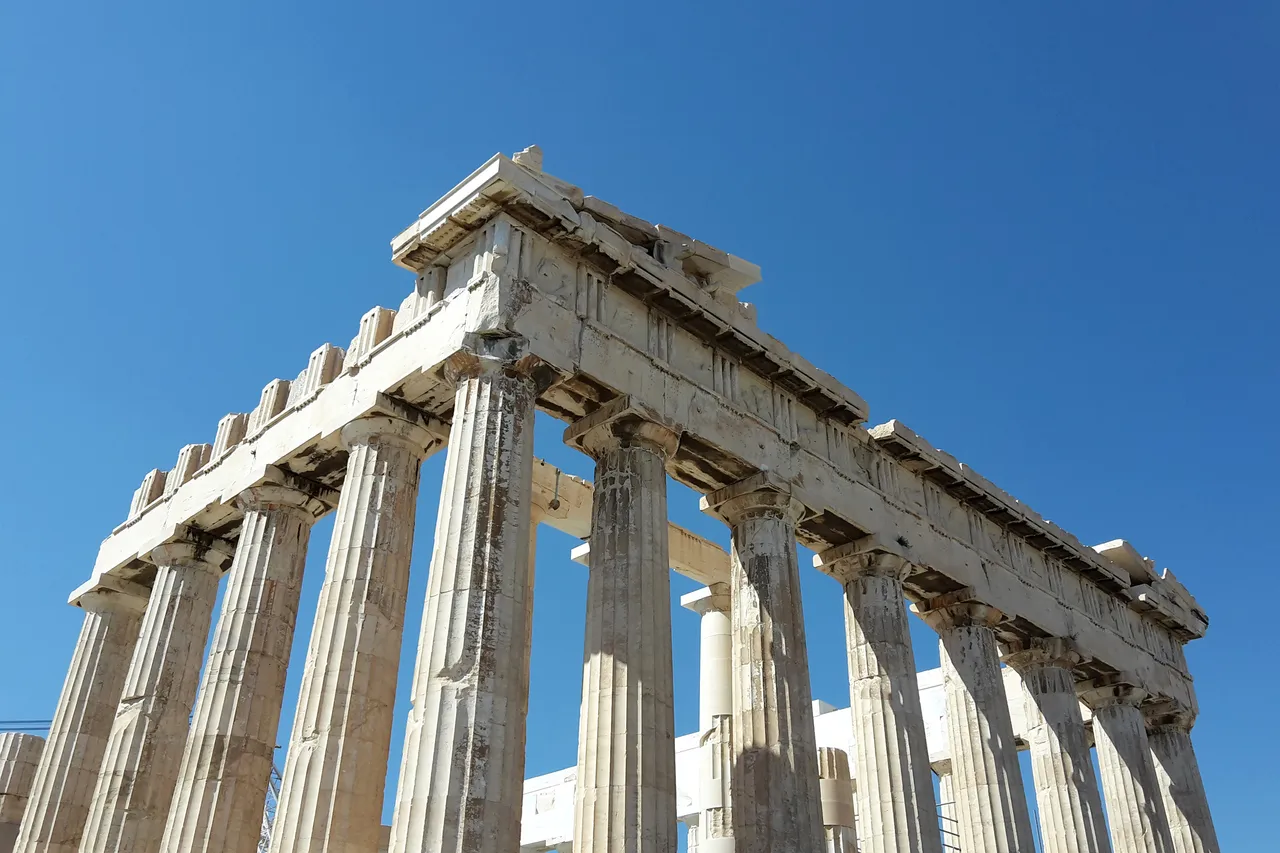 Marble columns of the Parthenon on the Acropolis in Athens, seen from below against a deep blue sky