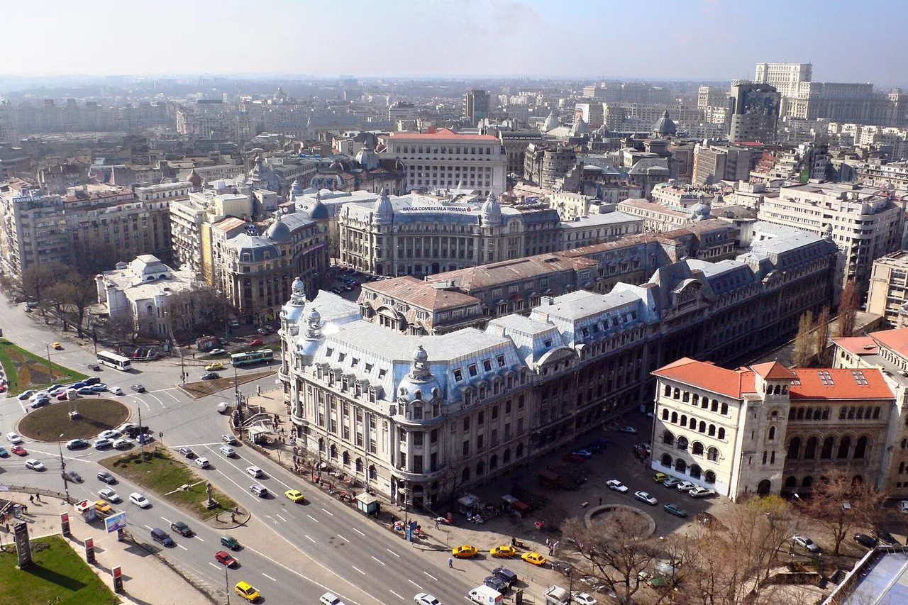 Central Bucharest seen from above, with University Square, wide boulevards full of traffic and the huge Palace of the Parliament on the horizon