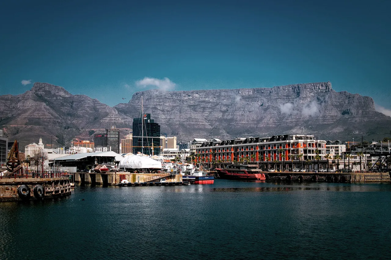 Table Mountain rising above the harbor and hotels of the V&A Waterfront in Cape Town
