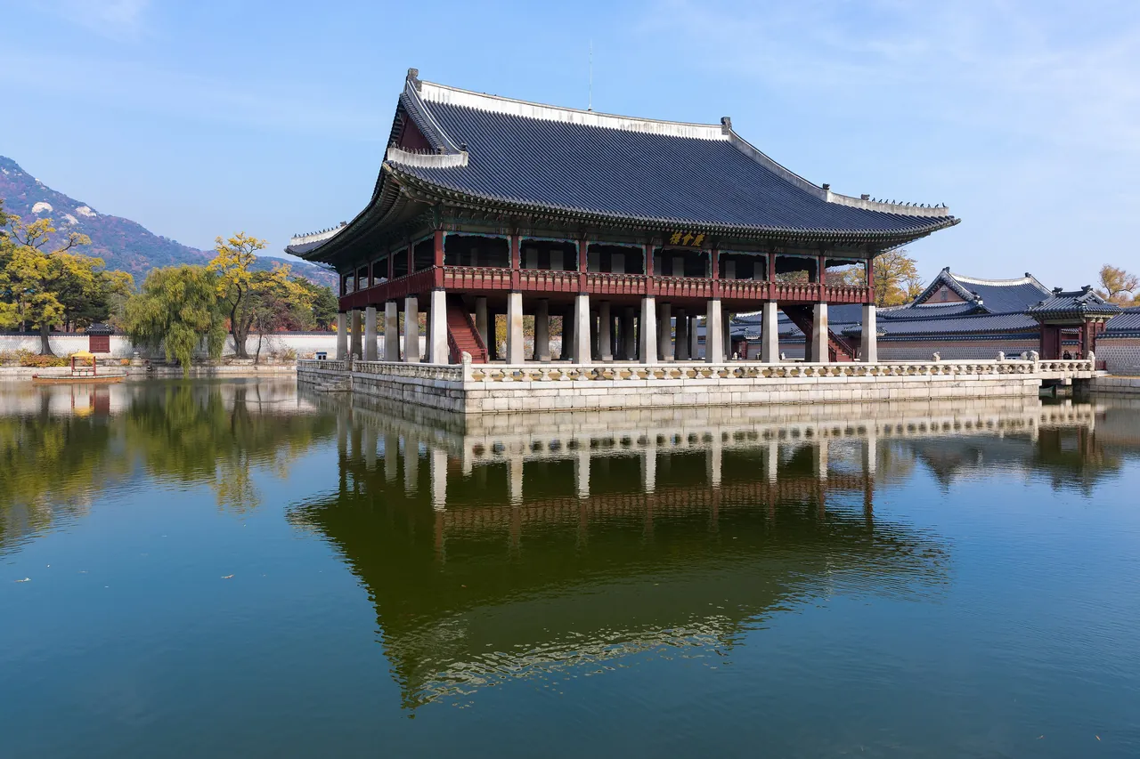 The Gyeonghoeru pavilion at Gyeongbokgung Palace in Seoul, reflected in its pond, with Bugaksan mountain behind