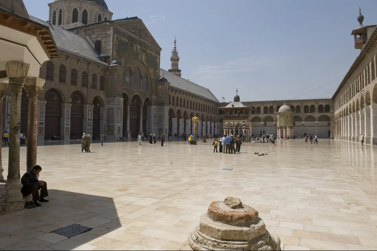 The marble courtyard of the Umayyad Mosque in Damascus, with its arcades, domed fountain and minarets