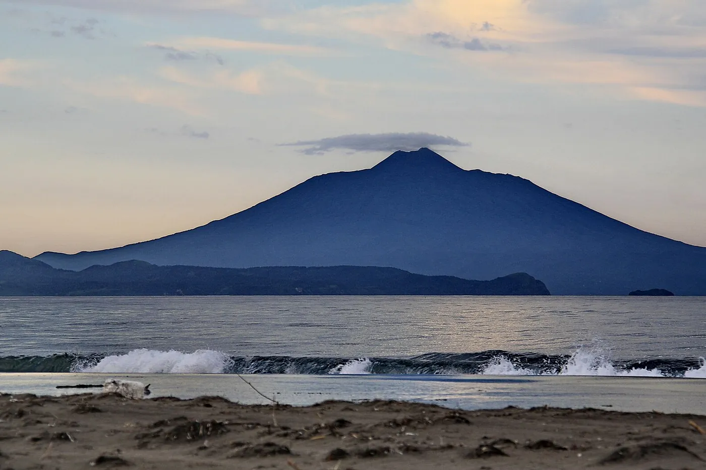 The cone of Tyatya volcano on Kunashir seen across the sea at dusk