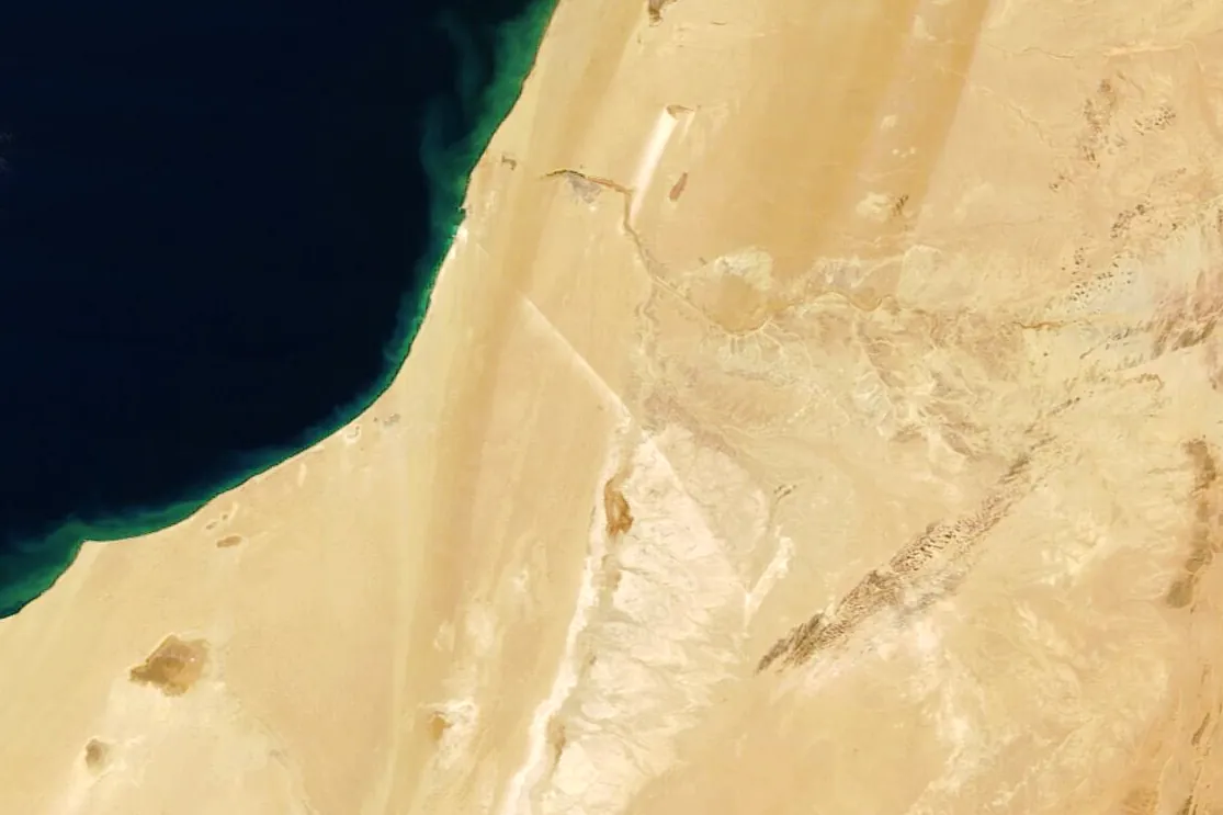 Satellite image of the Atlantic coast of Western Sahara with the thin white line of the Bou Craa conveyor belt